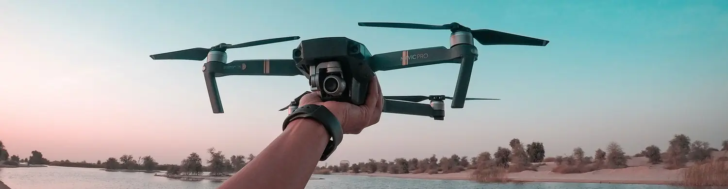 Papa's Aerial pilot holding a folding camera drone before a flight