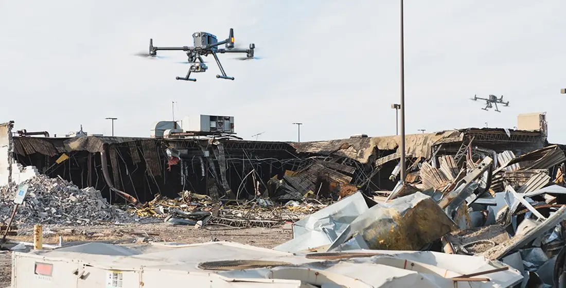 Drone flying over a collapsed and burned structure during a damage survey