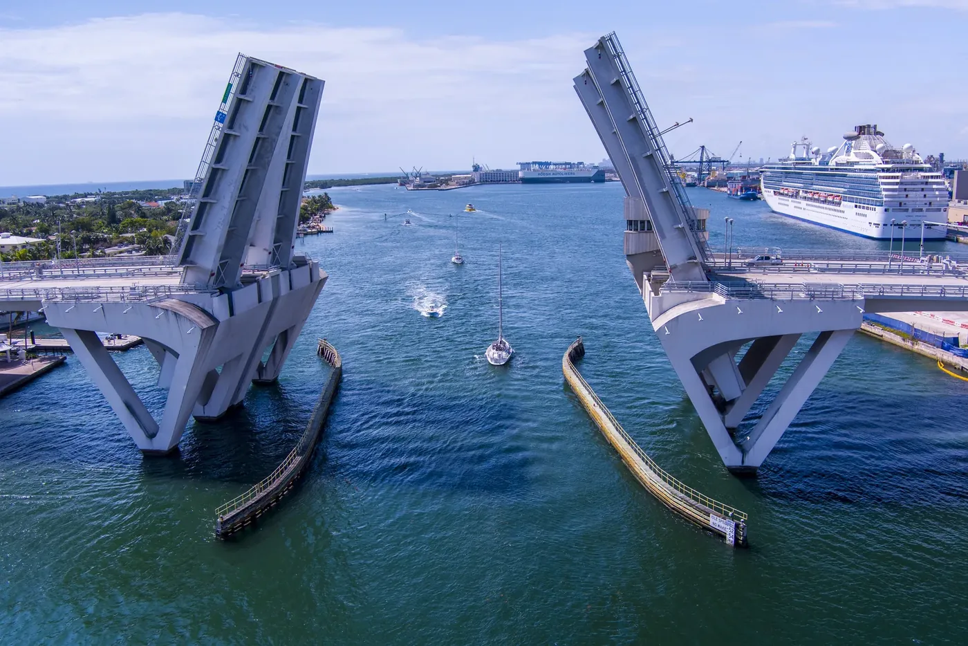 A drawbridge standing open with cruise ships at the terminal behind it
