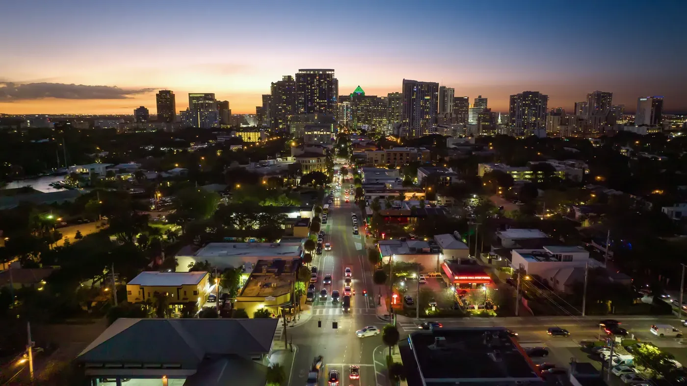 The city at dusk with the downtown towers lit against a burning sky