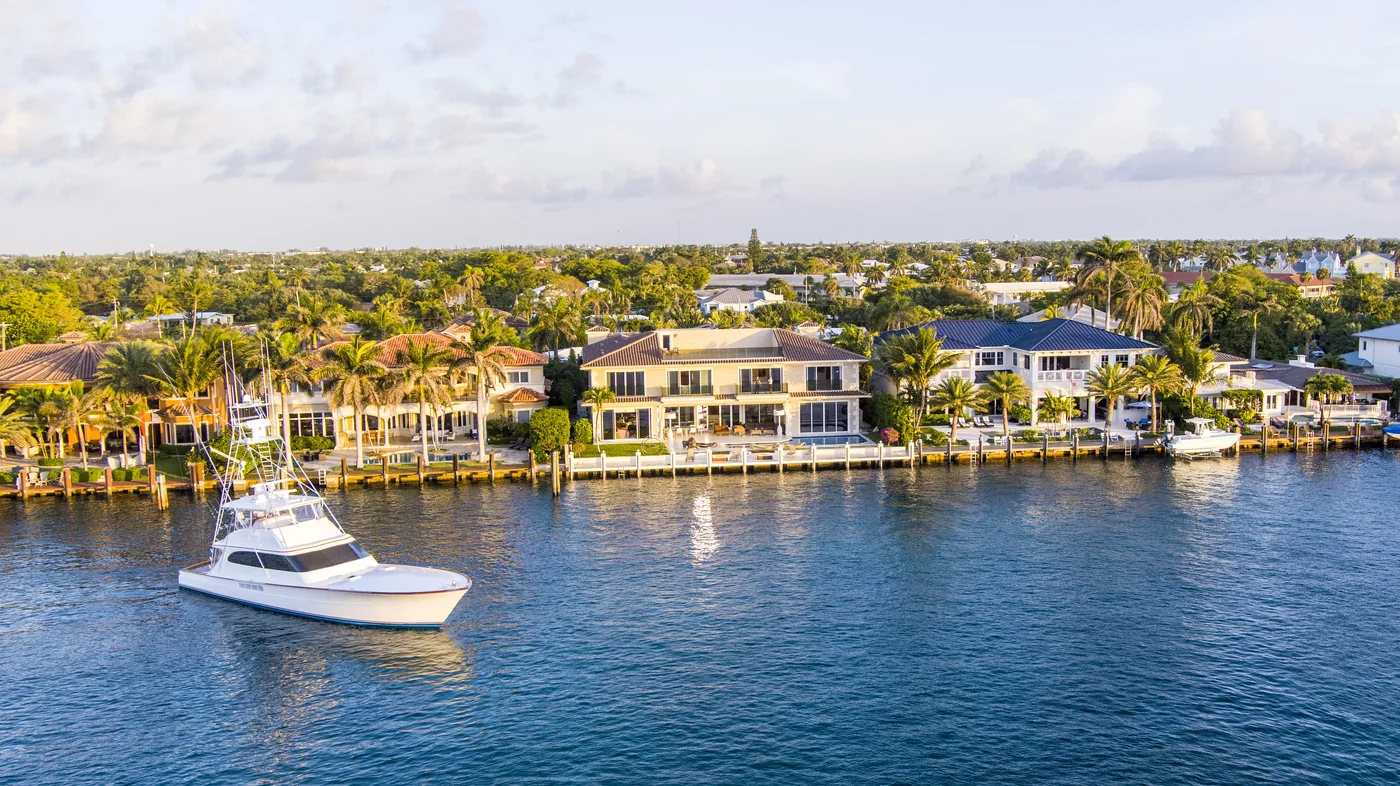 A sportfishing boat under way on the Intracoastal past a row of waterfront homes and docks