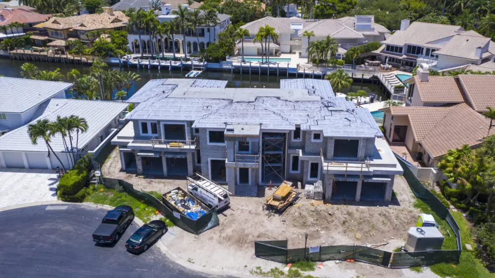 Large waterfront home under construction, photographed from directly above