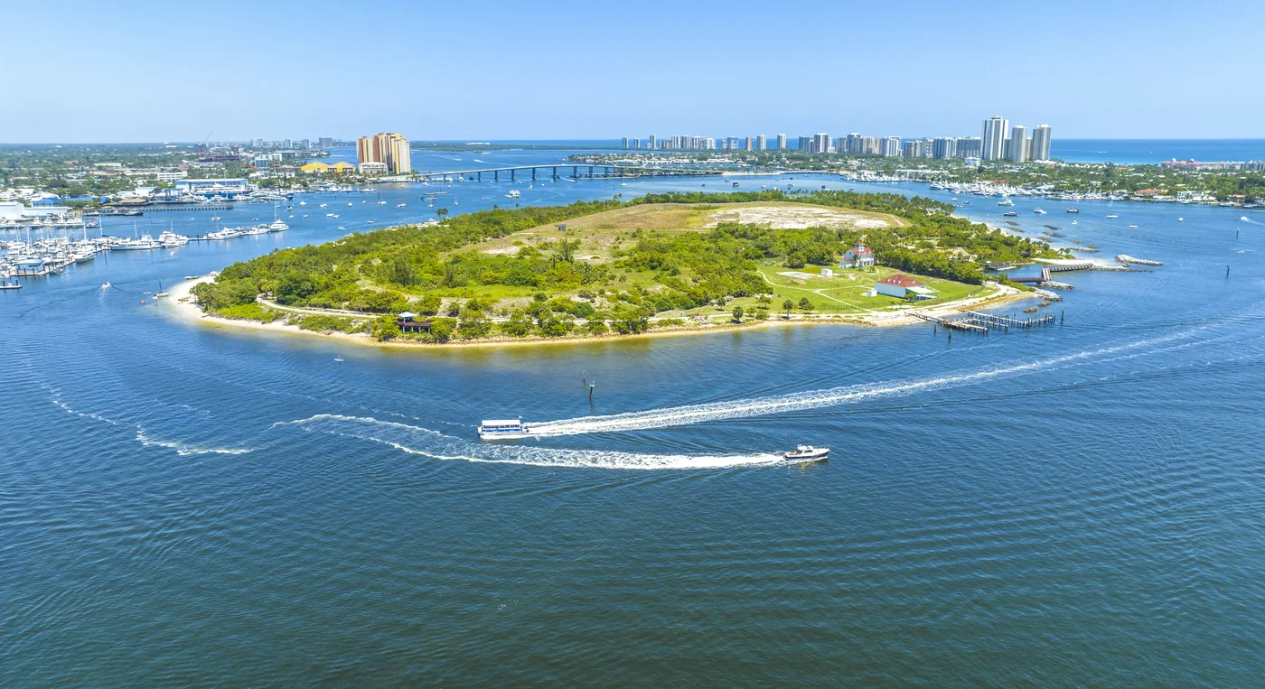 Peanut Island in the Intracoastal ringed by boats, with the bridge and skyline behind